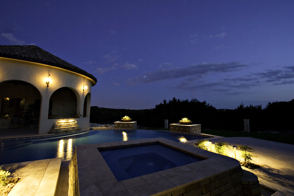 Image of a pool that is lit from lawn and pool lights