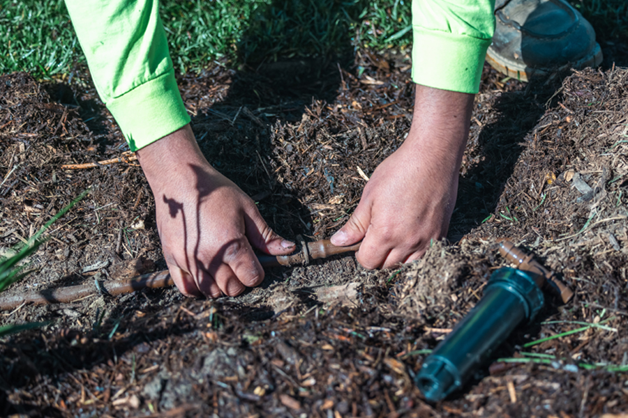 image of a tech preforming maintenance on a sprinkler