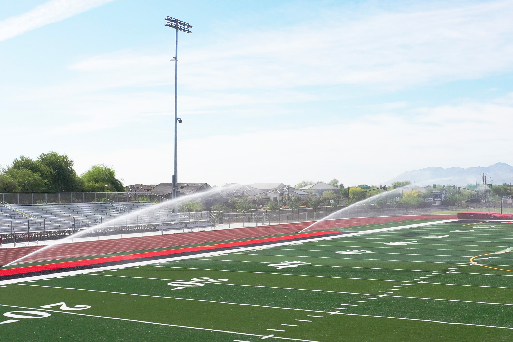 image of a football field being watered by sprinklers