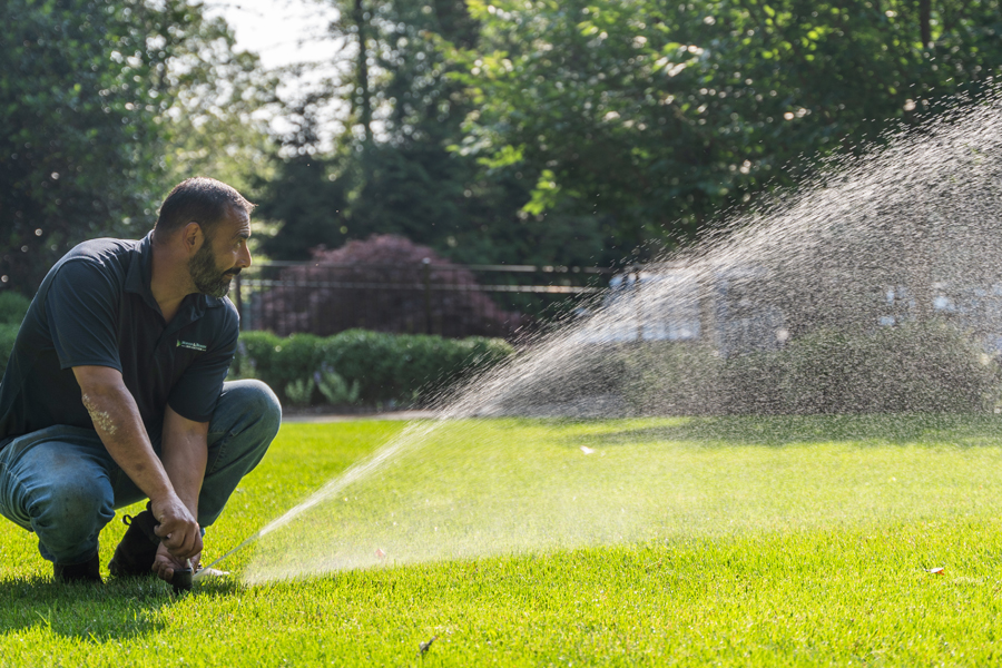Image of a tech servicing a sprinkler