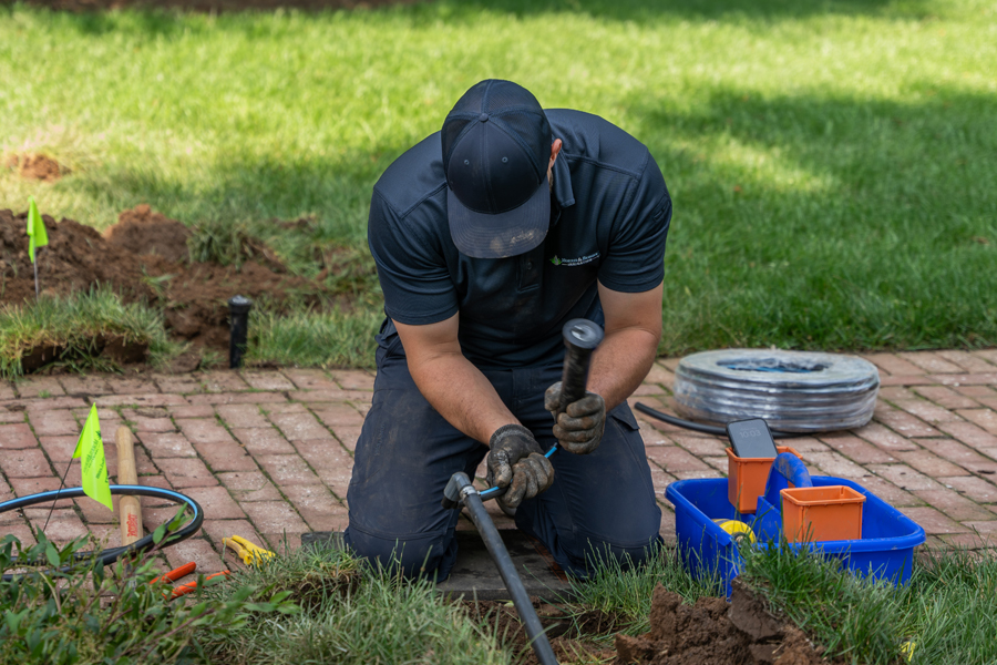 image of a tech installing a lawn sprinkler